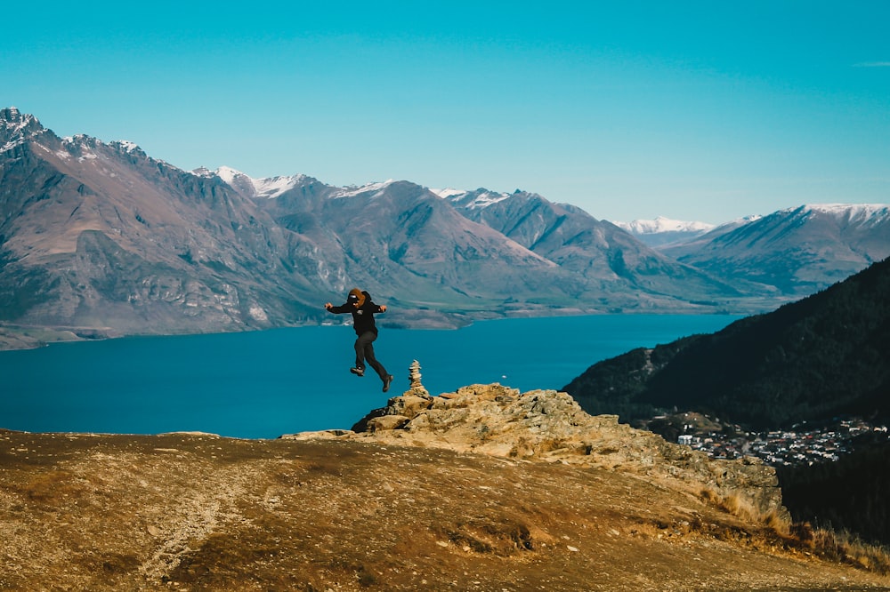 person standing on rock near body of water during daytime