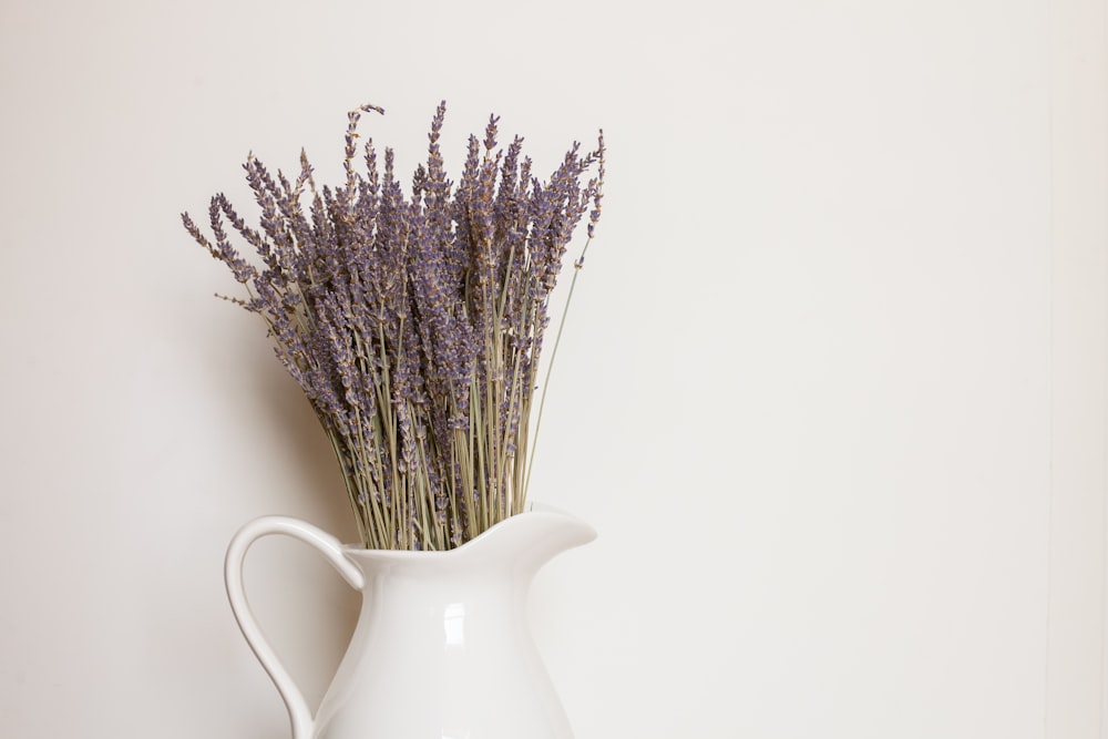 white ceramic vase with purple flowers