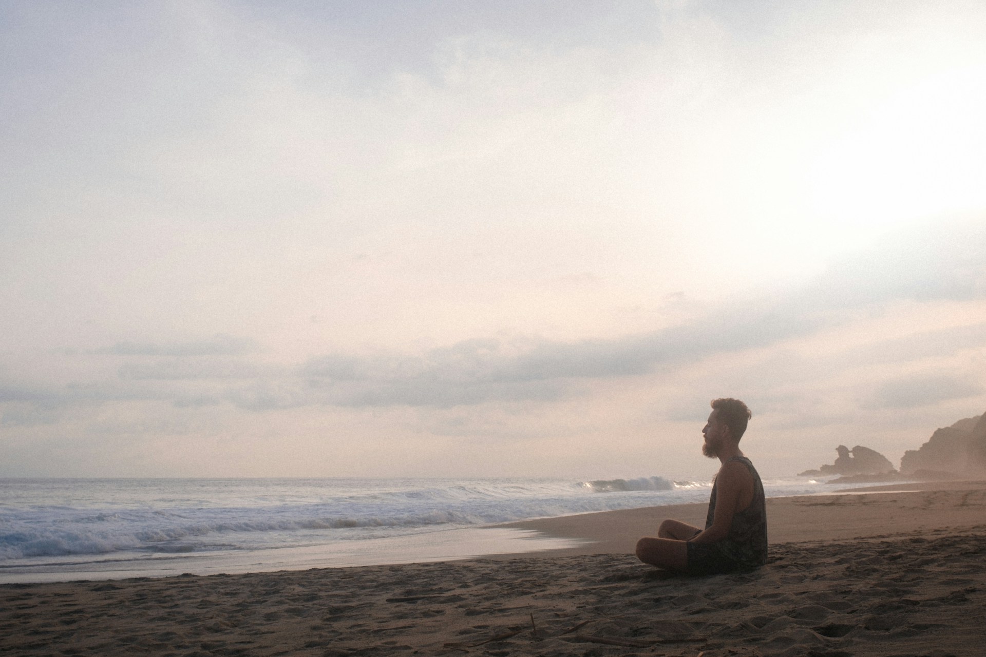 woman sitting on beach during daytime