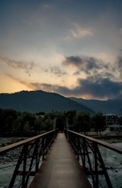 brown wooden bridge over the mountain during daytime