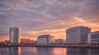 city skyline across body of water during sunset