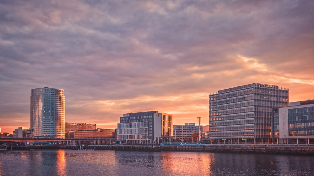 city skyline across body of water during sunset