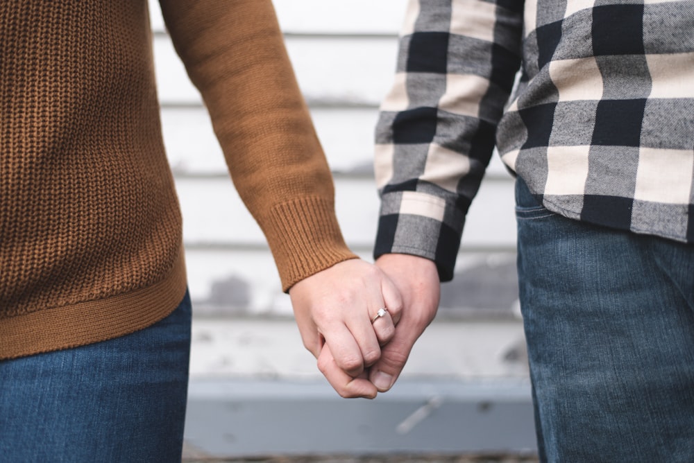person in brown sweater holding hands with woman in brown sweater
