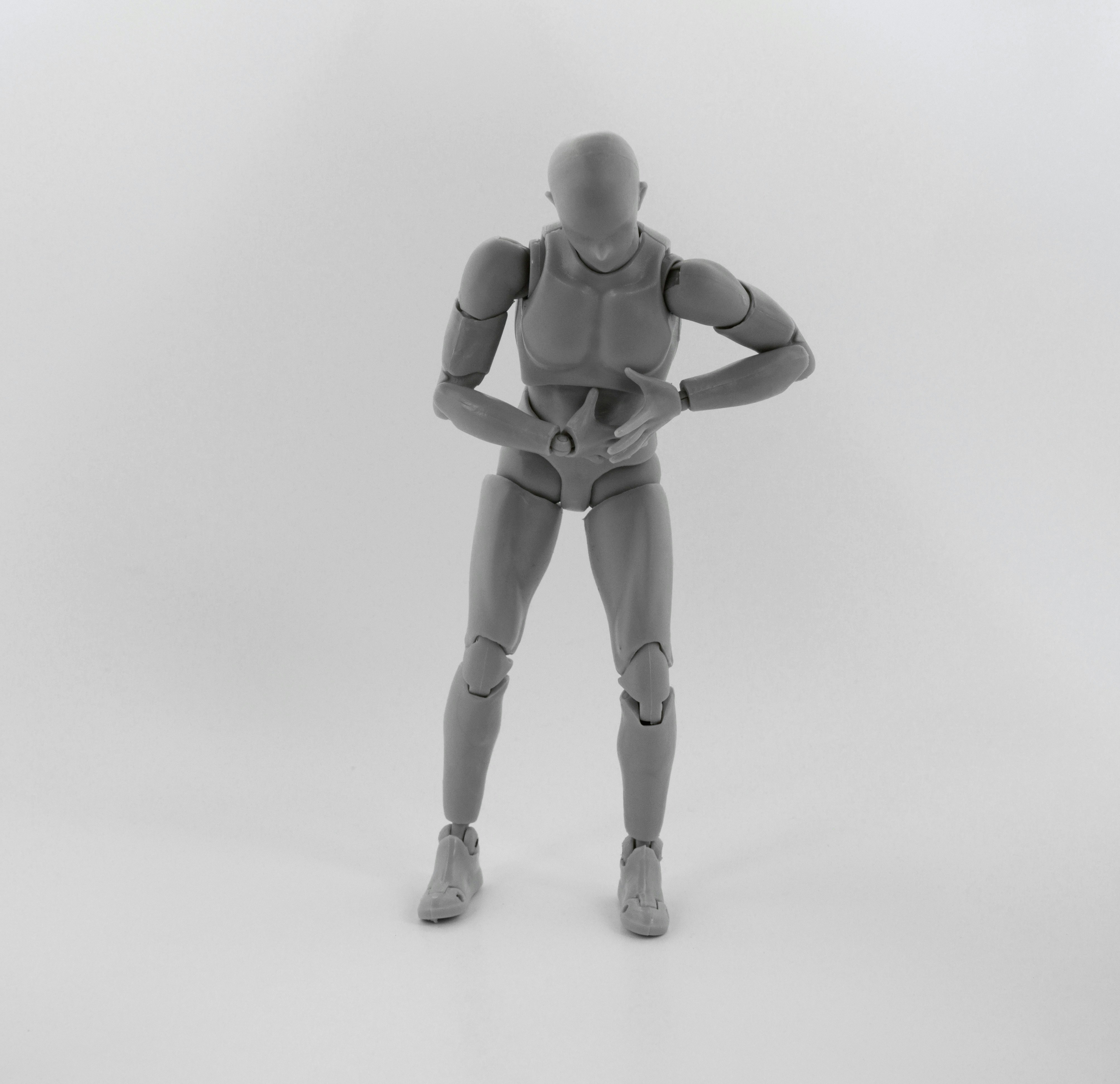 gray robot action figure on white surface