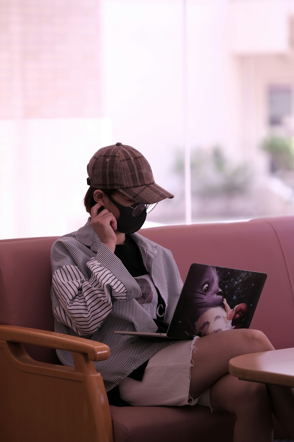 man in black sunglasses and gray pinstripe dress shirt using macbook