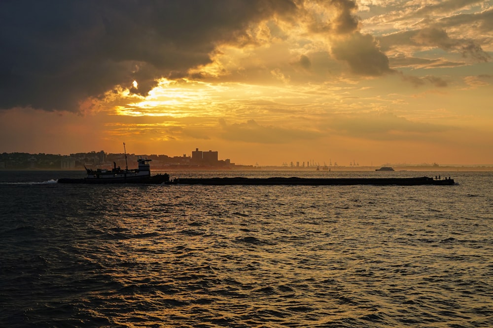 silhouette of boat on sea during sunset