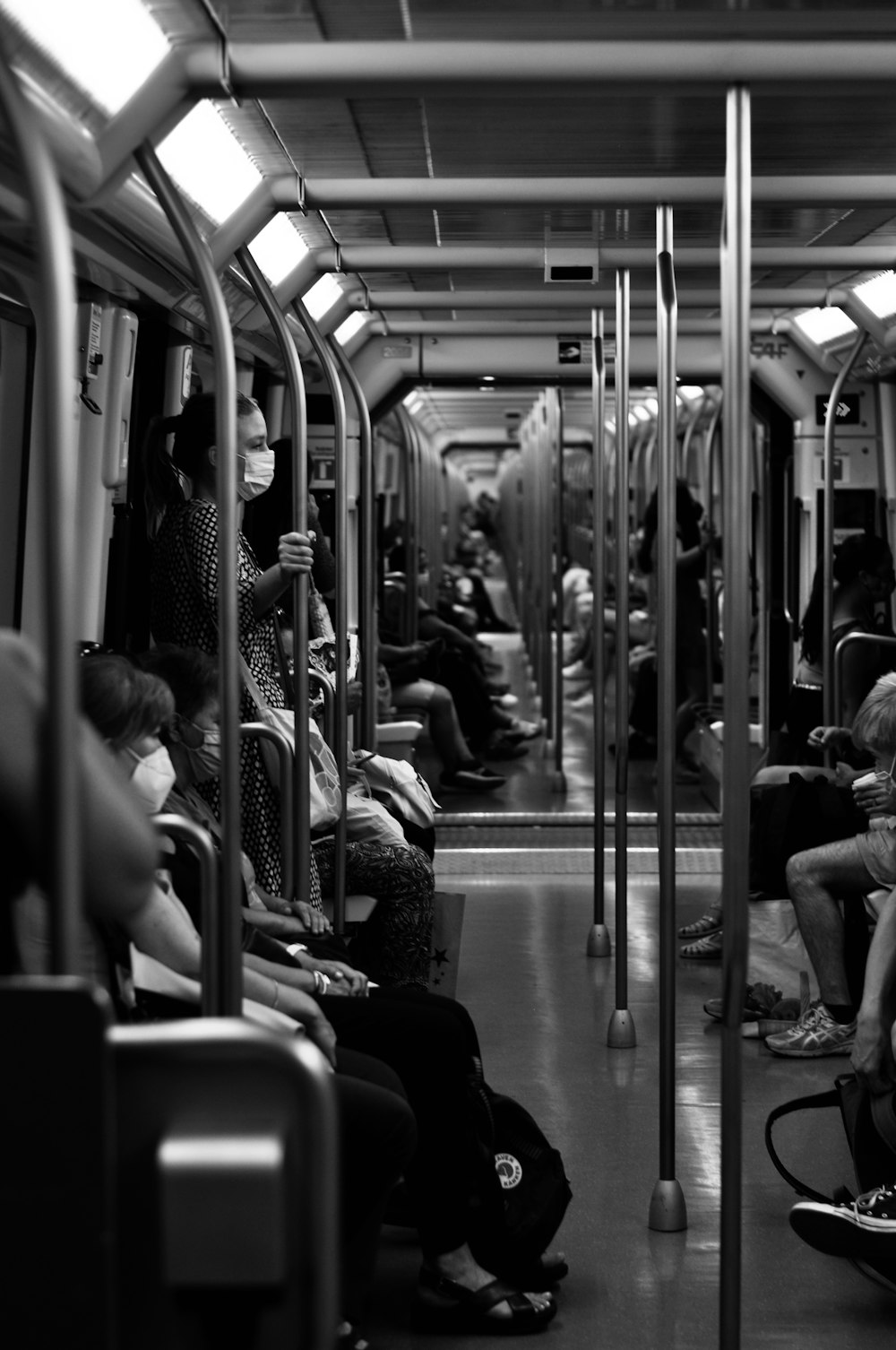 grayscale photo of people sitting on train