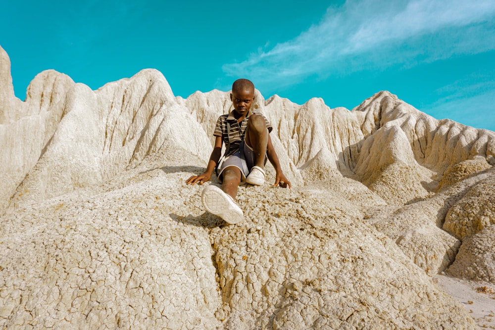 a man sitting on a rock in the desert