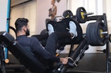 man in black long sleeve shirt sitting on black exercise equipment