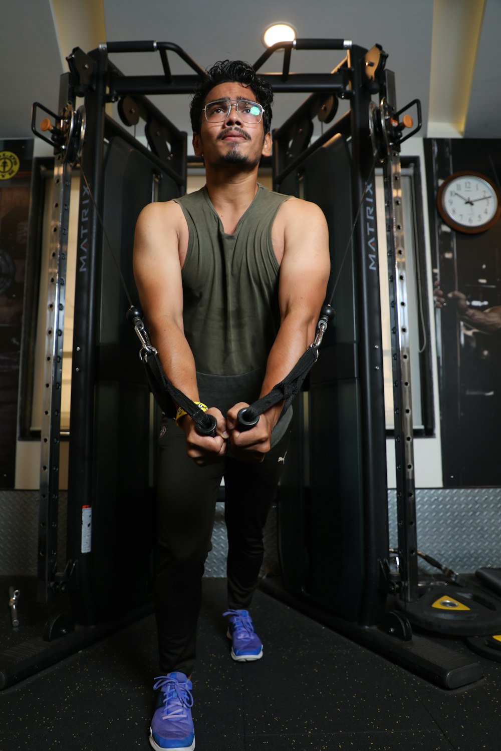 man in black tank top and black pants holding black and brown leather belt