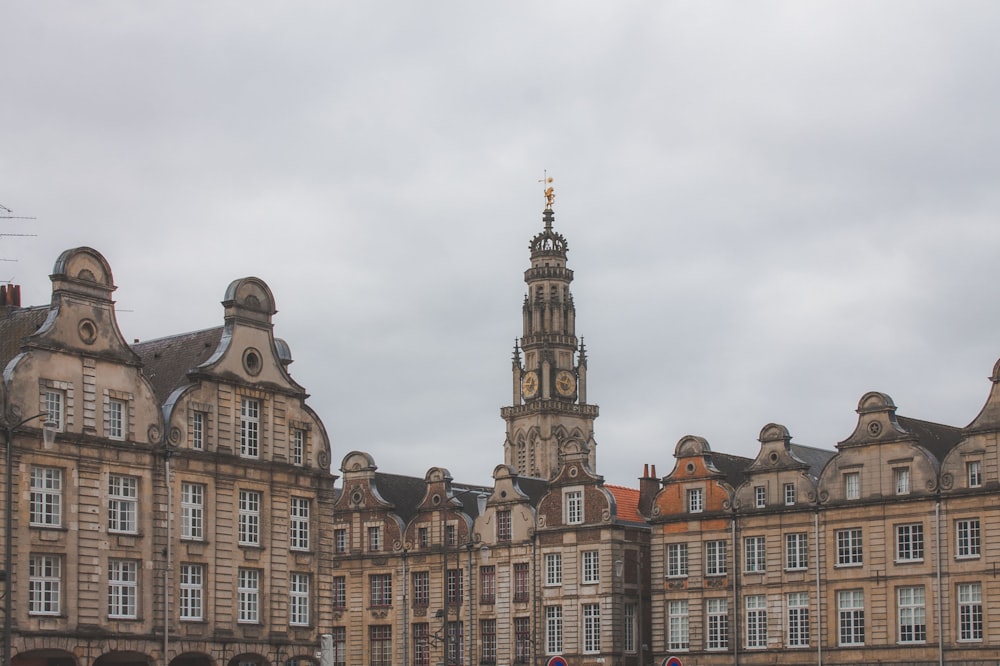 brown and white concrete building under white clouds during daytime