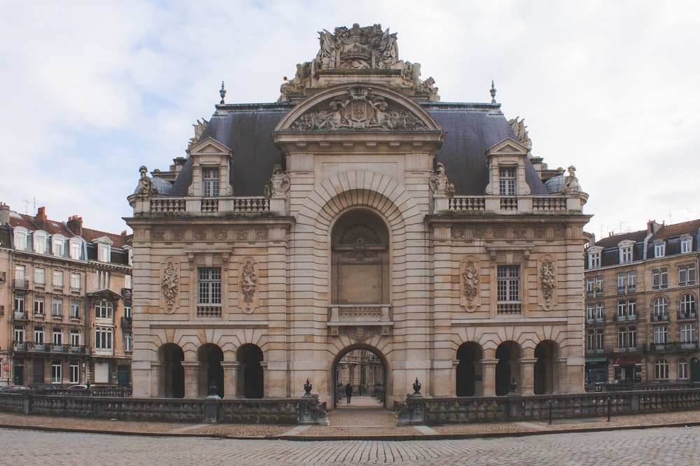 Weißes Betongebäude unter weißen Wolken tagsüber