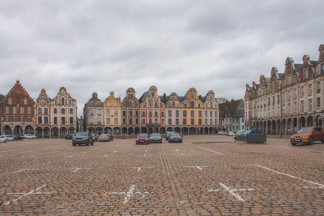 cars parked in front of brown concrete building during daytime