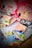 The image contains two children's backpacks with cartoon sheep designs, surrounded by various school supplies. The supplies include notebooks, scissors, a ruler, highlighters, an eraser, and colored markers. The backpacks have pink and red tones with decorative elements.