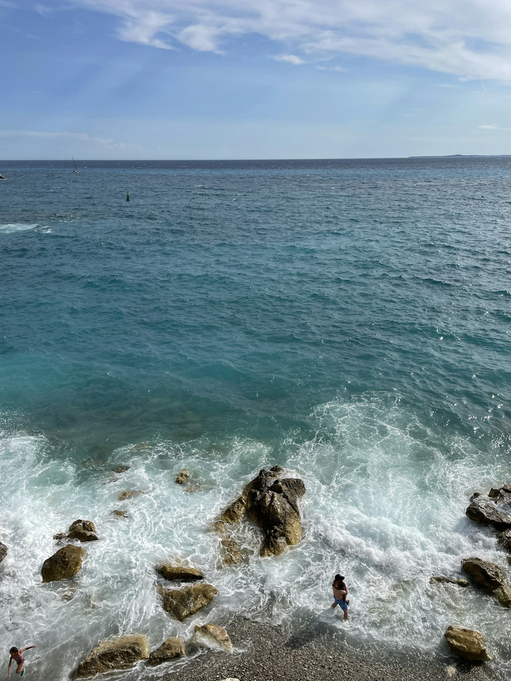 sea waves crashing on rocks during daytime