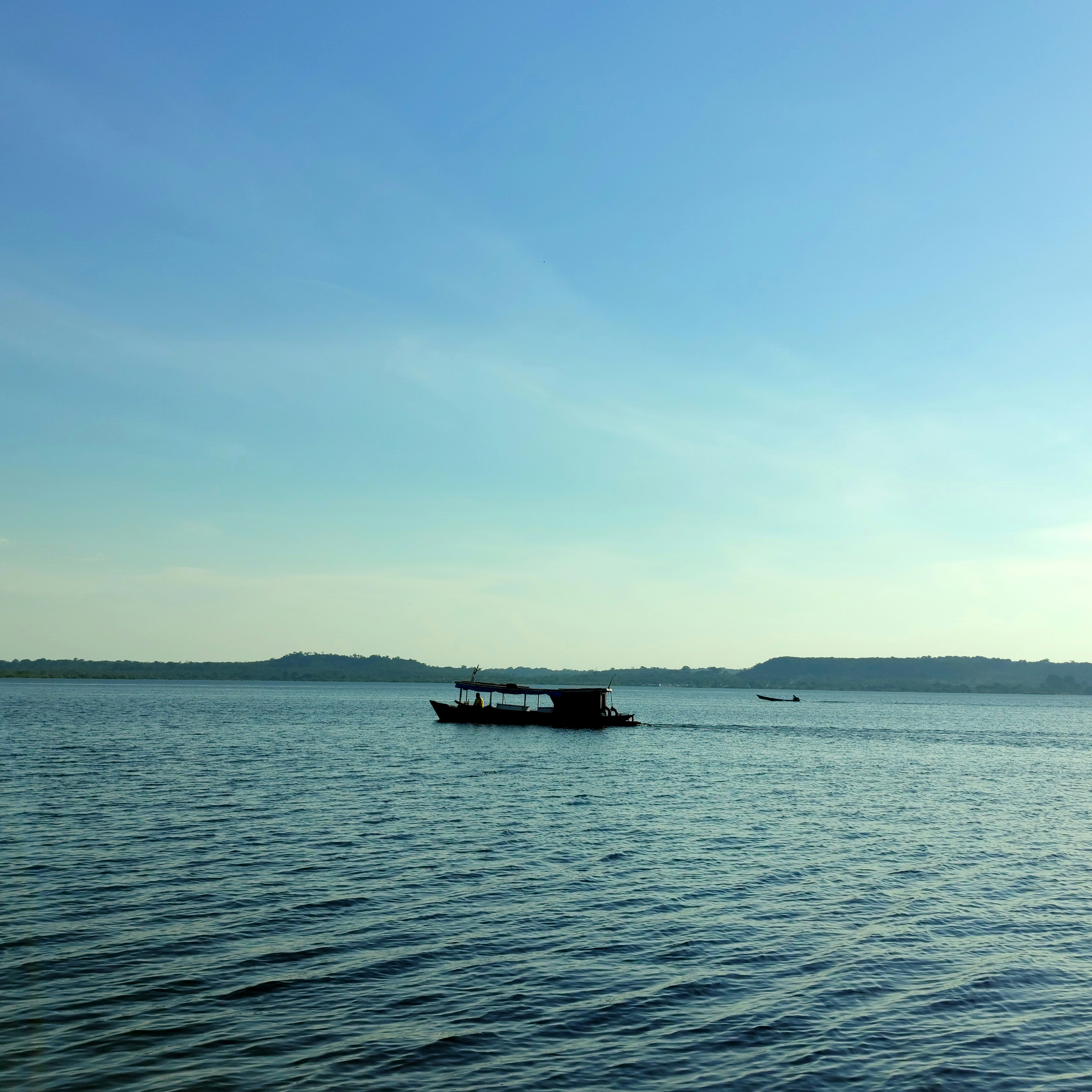 black boat on sea under blue sky during daytime