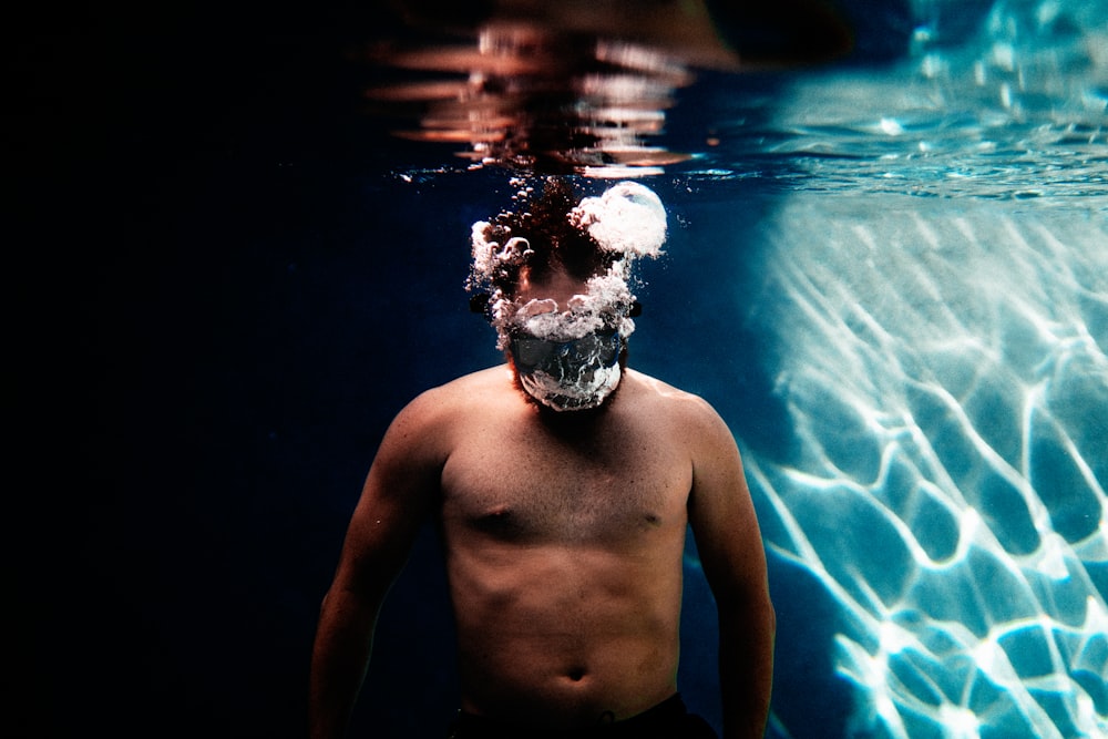 Oben-ohne-Mann mit weißer und schwarzer Totenkopf-Gesichtsbemalung im Wasser