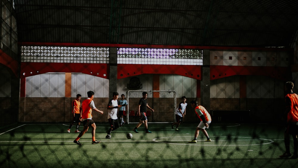 group of people playing soccer on field during daytime