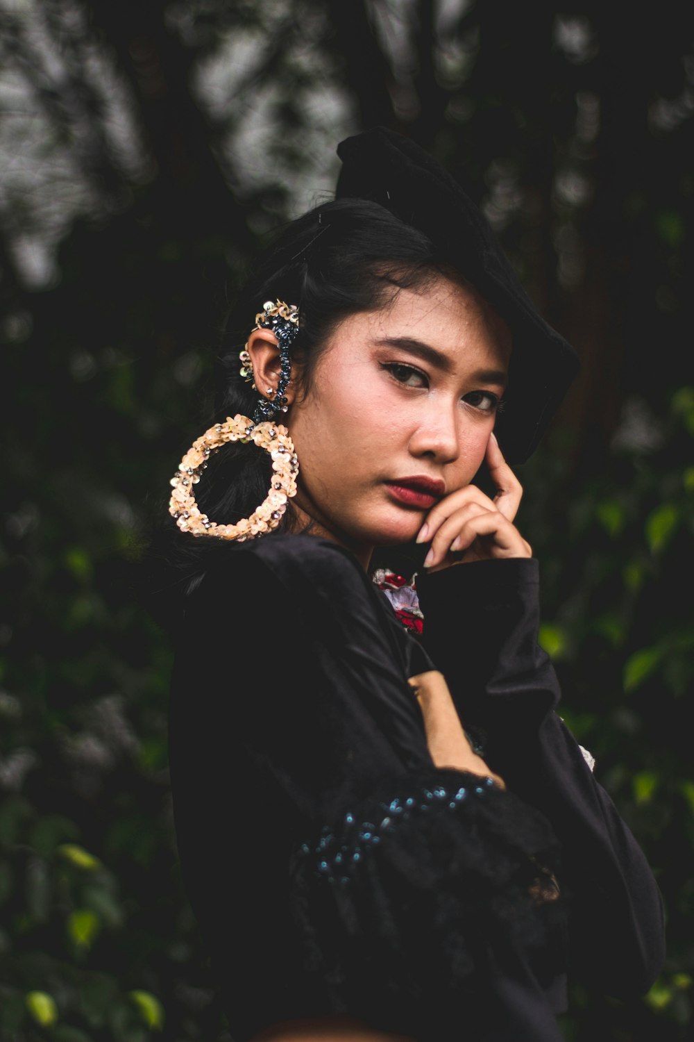 a woman in a black dress and a pair of earrings