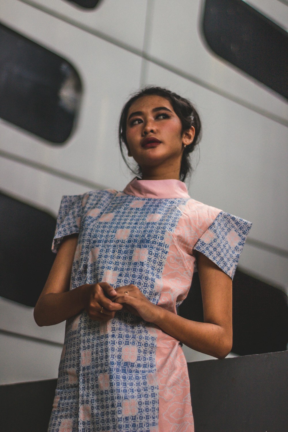 a woman standing in front of a white wall