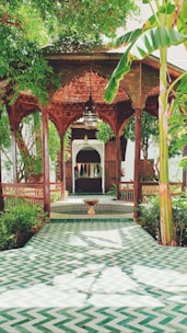An elegant wooden pendopo structure surrounded by lush greenery.