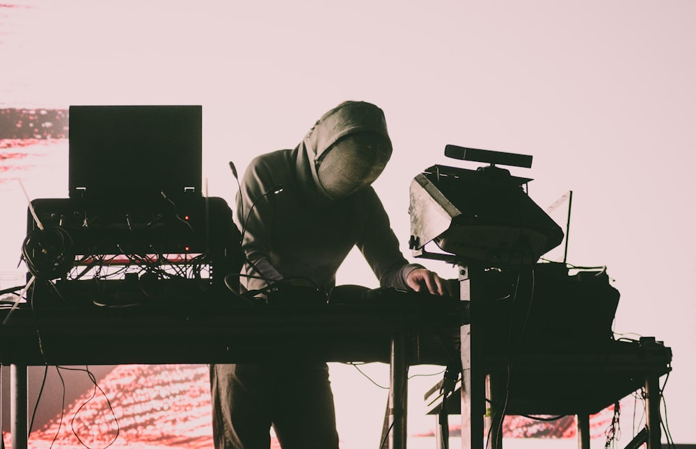 man in gray hoodie playing piano