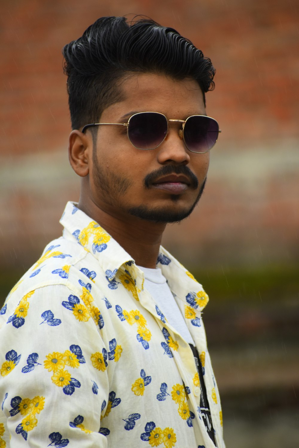 man in white yellow and blue floral button up shirt wearing black sunglasses