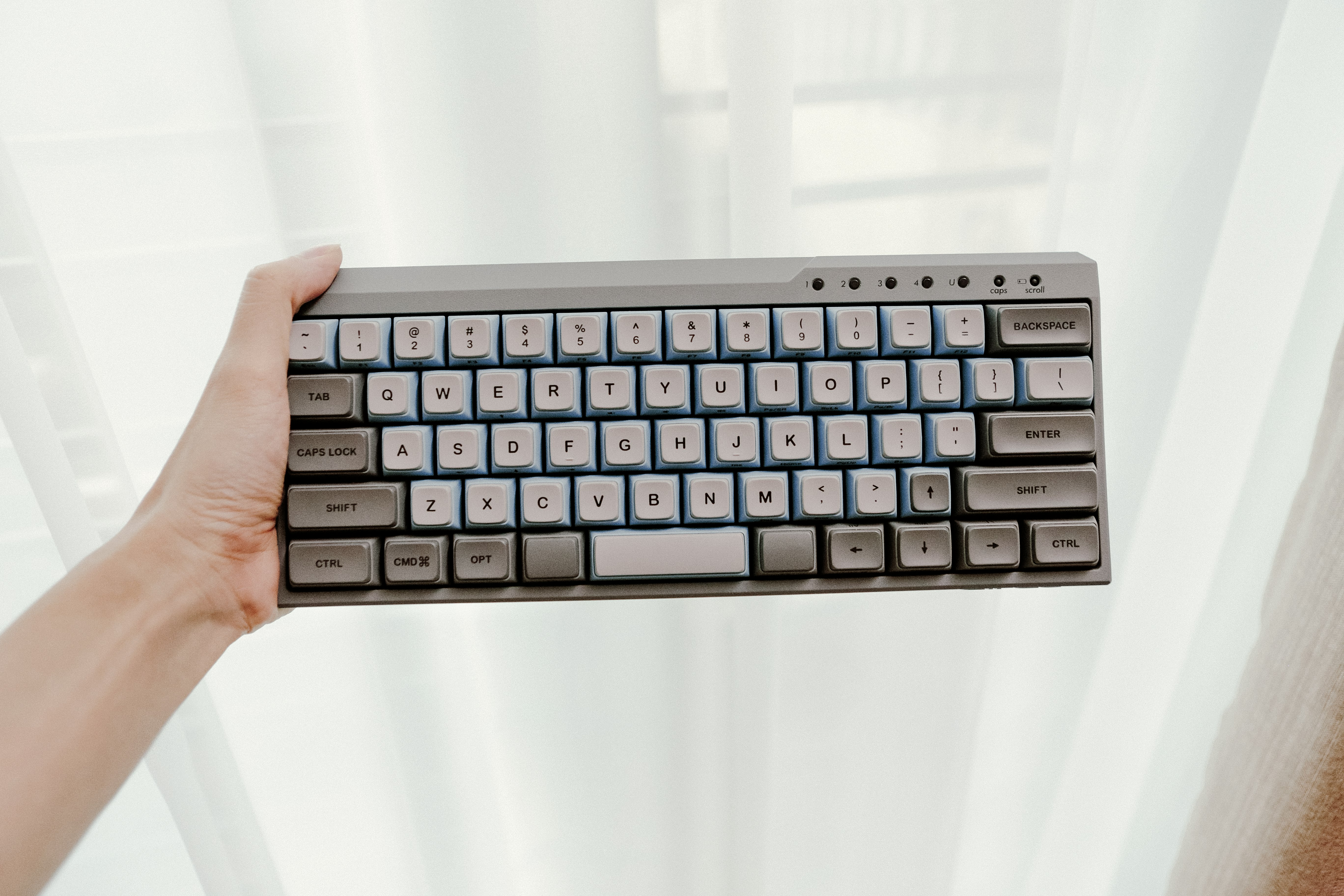 person holding black cordless computer keyboard