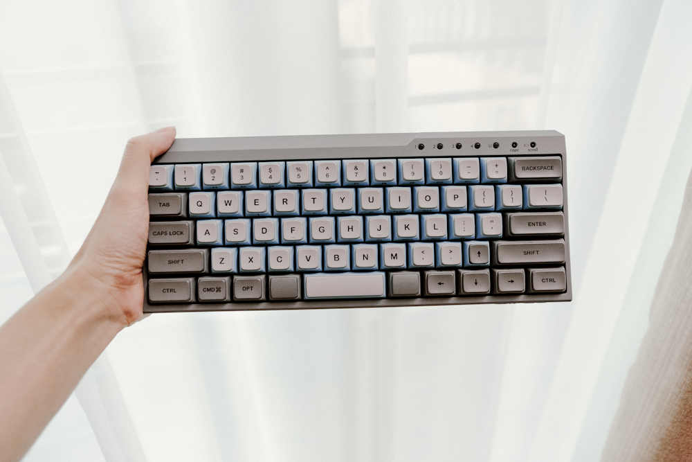 person holding black cordless computer keyboard