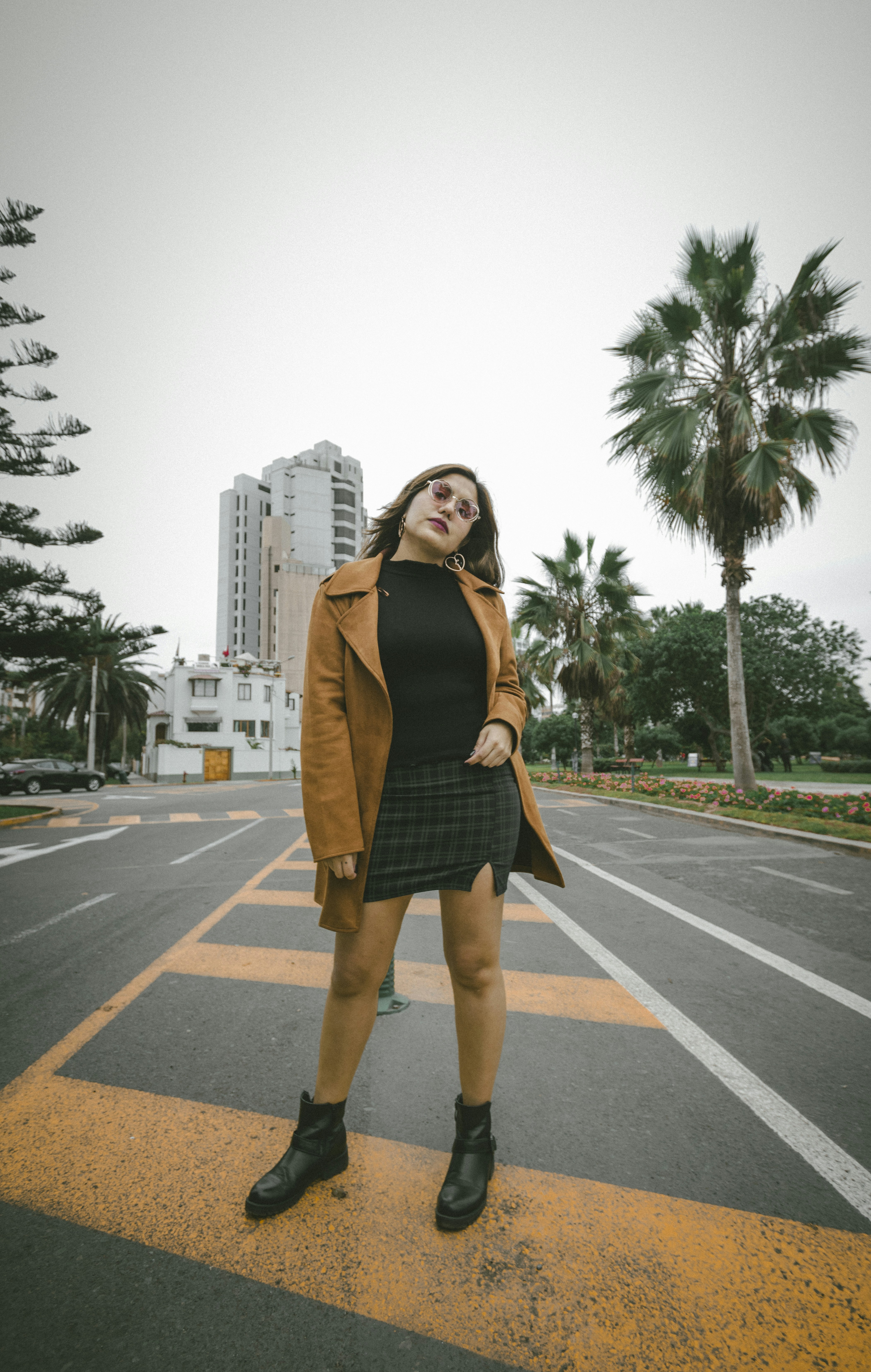 woman in black sleeveless dress standing on road during daytime