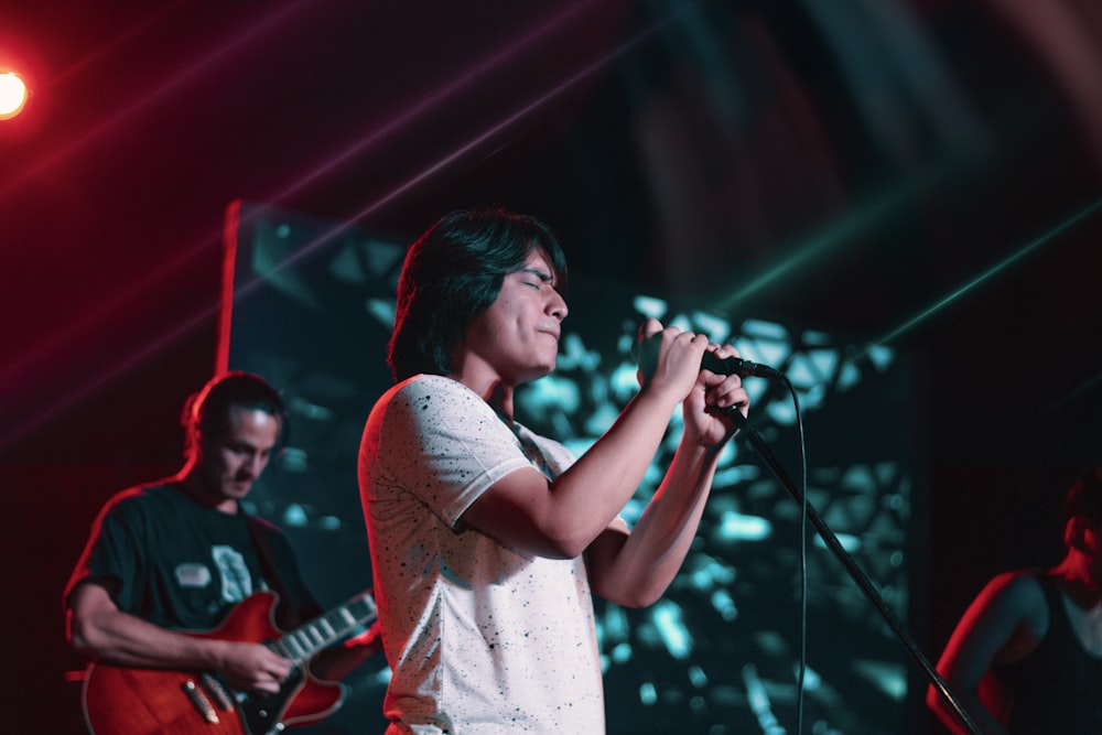 woman in white shirt singing on stage