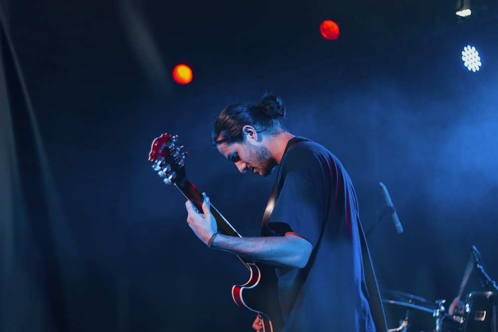 man in black shirt playing guitar