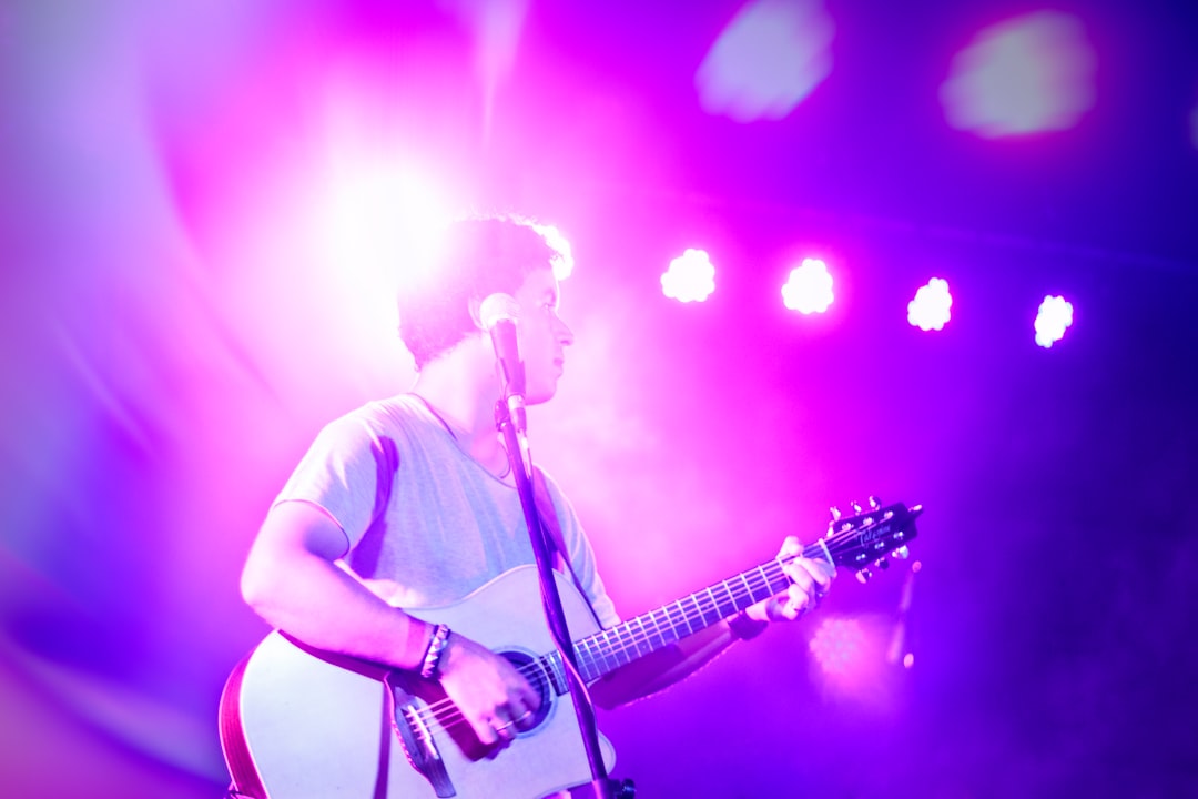 man in white t-shirt singing on stage