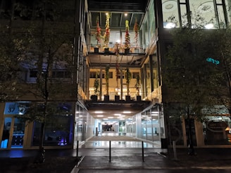 Exterior night view of Farmavale Pimenteira illuminated with brand colors.