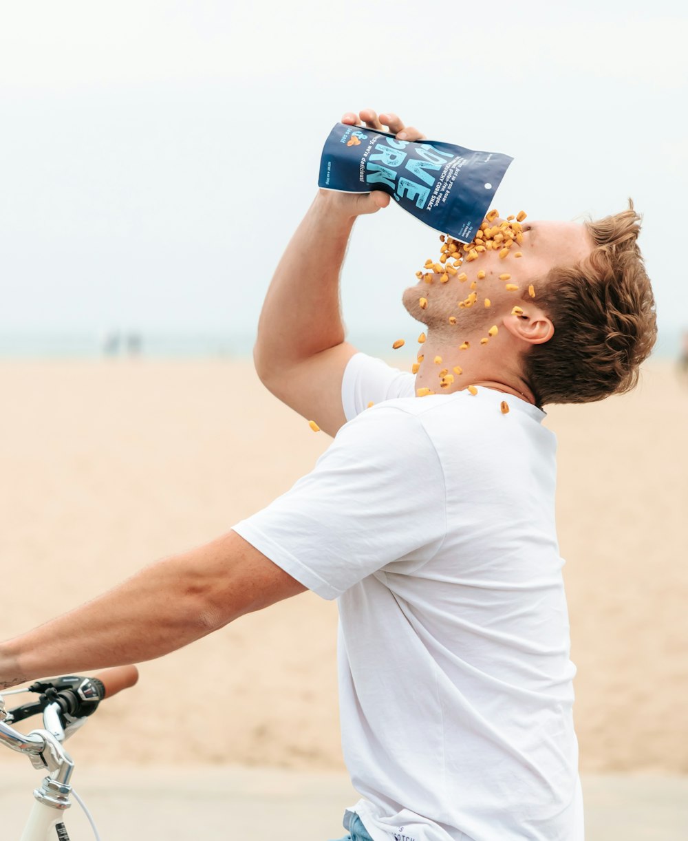 man in white t-shirt drinking water from bottle