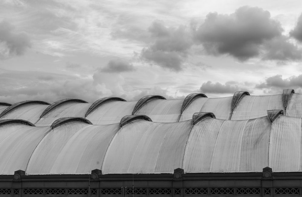 grayscale photo of building under cloudy sky