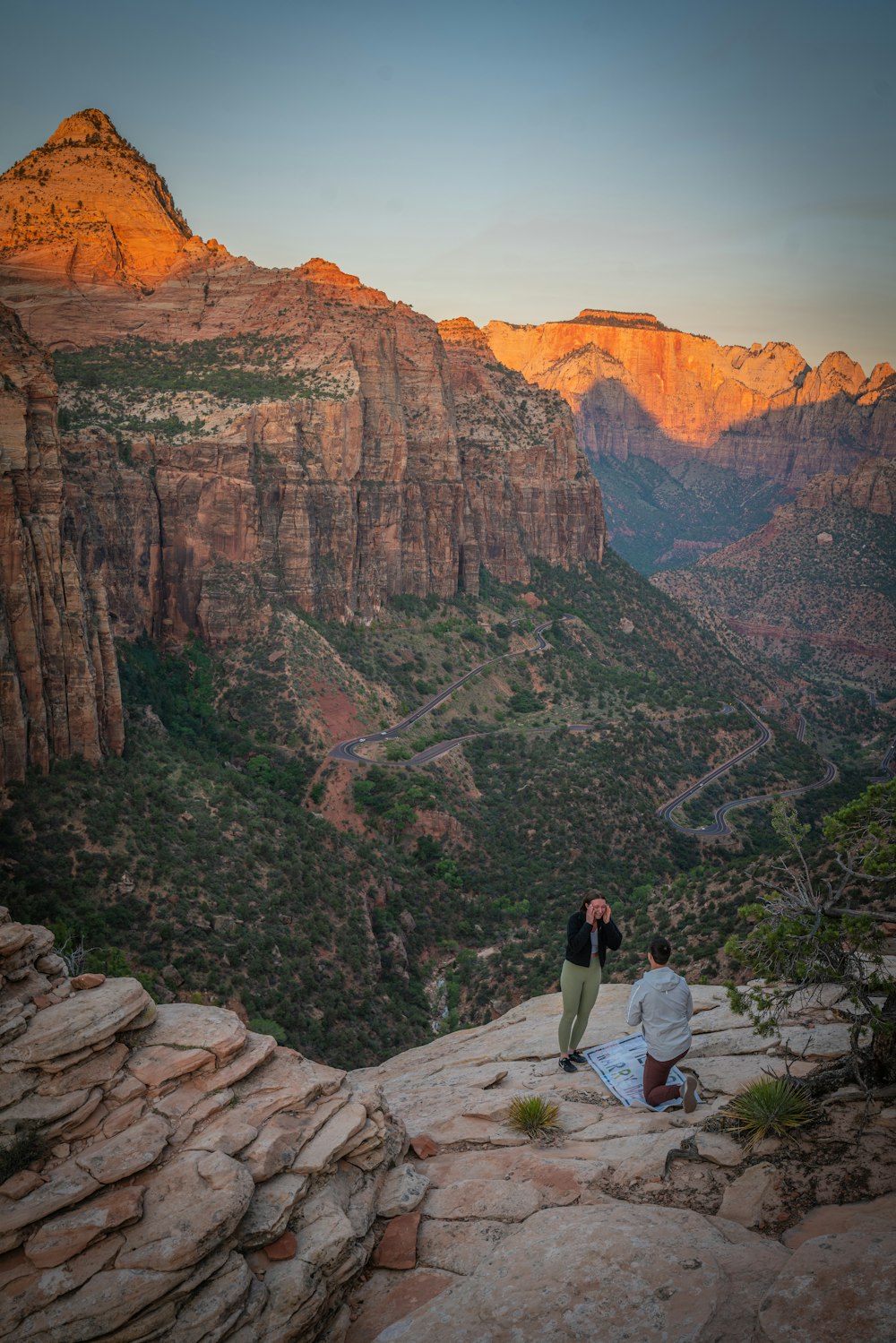 man in white shirt and black pants standing on brown rock mountain during daytime