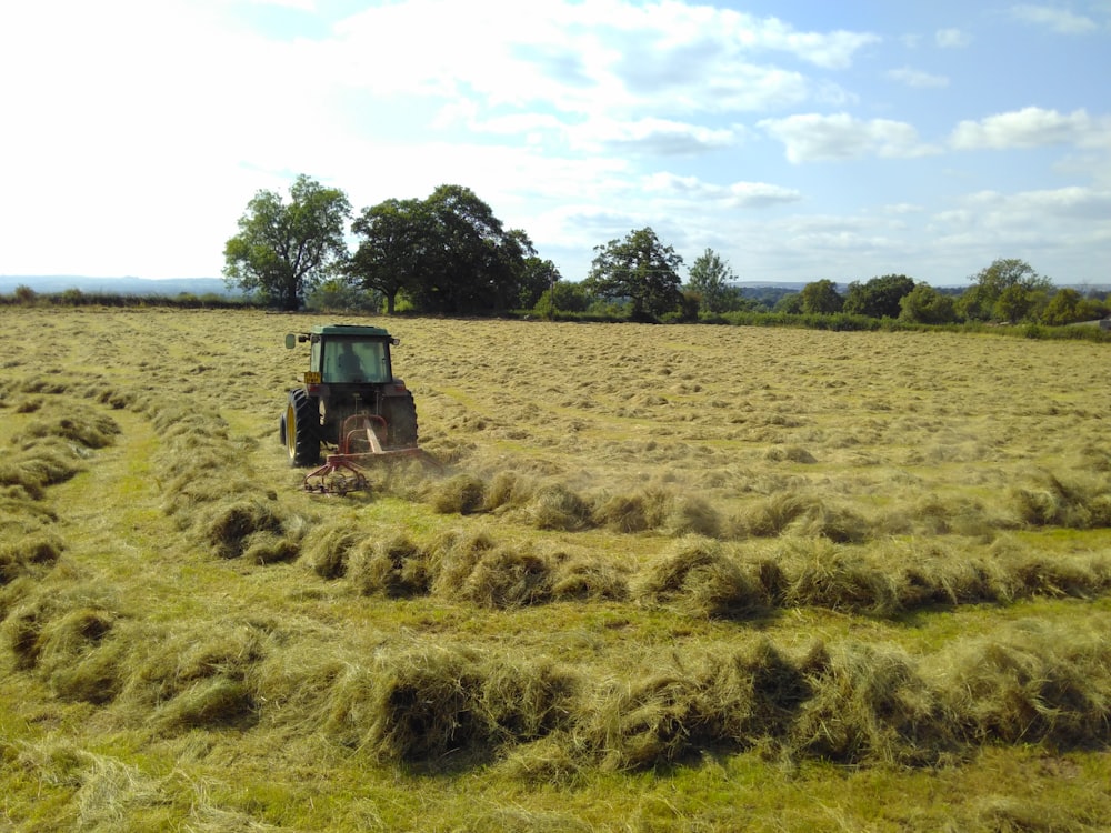 man riding tractor on green grass field during daytime