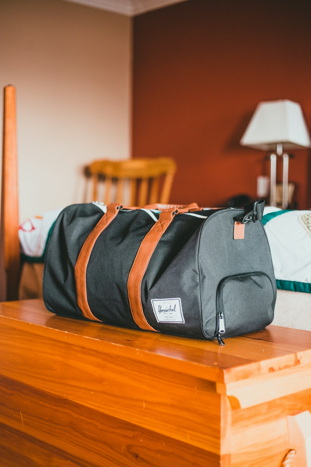 gray and orange backpack on brown wooden table