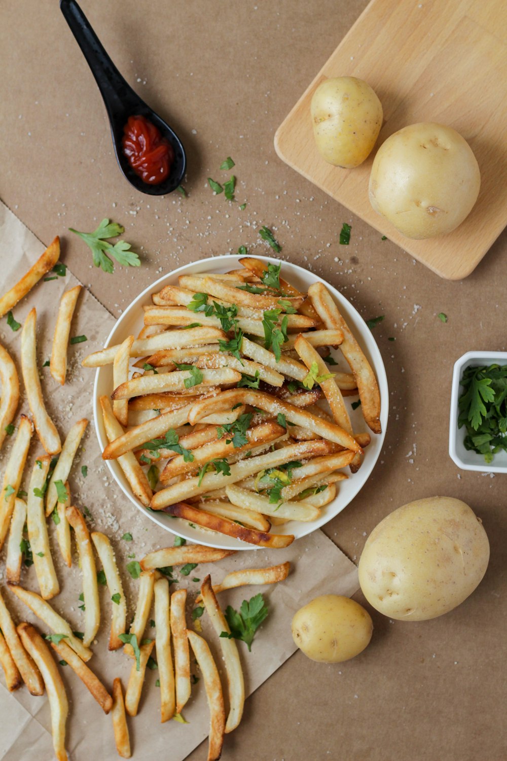 Kartoffelpommes und geschnittene Kartoffeln auf weißem Keramikteller