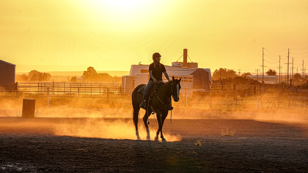 hombre montando a caballo en la playa durante la puesta del sol