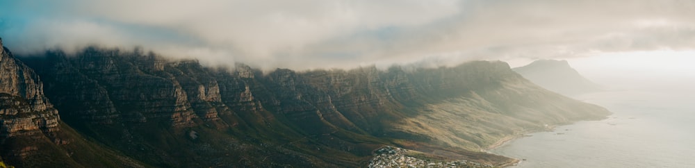 green trees on mountain under white clouds during daytime