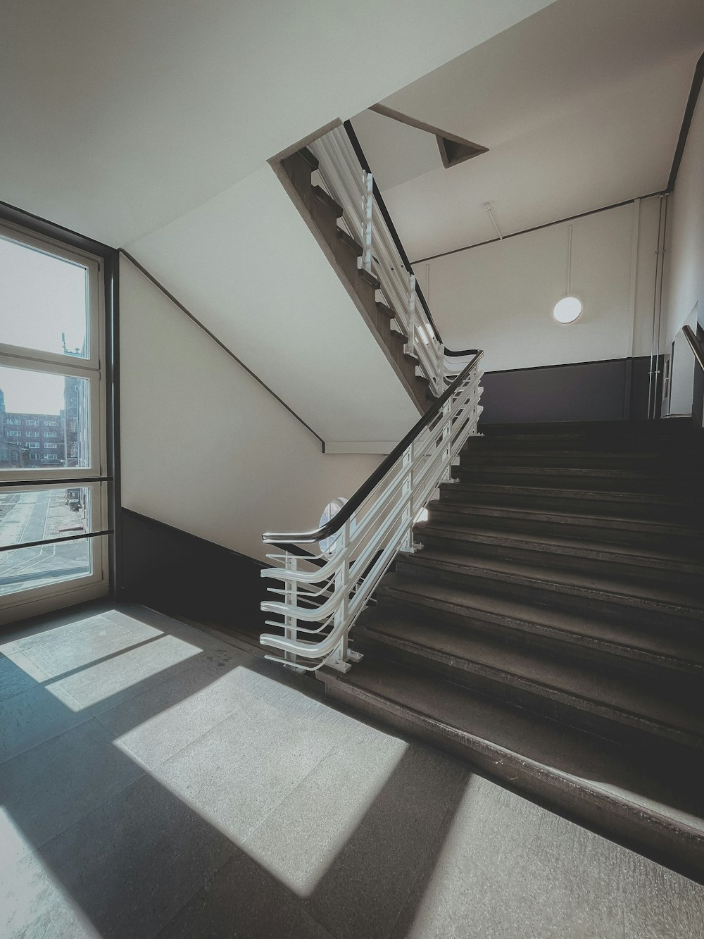 brown wooden staircase near glass window