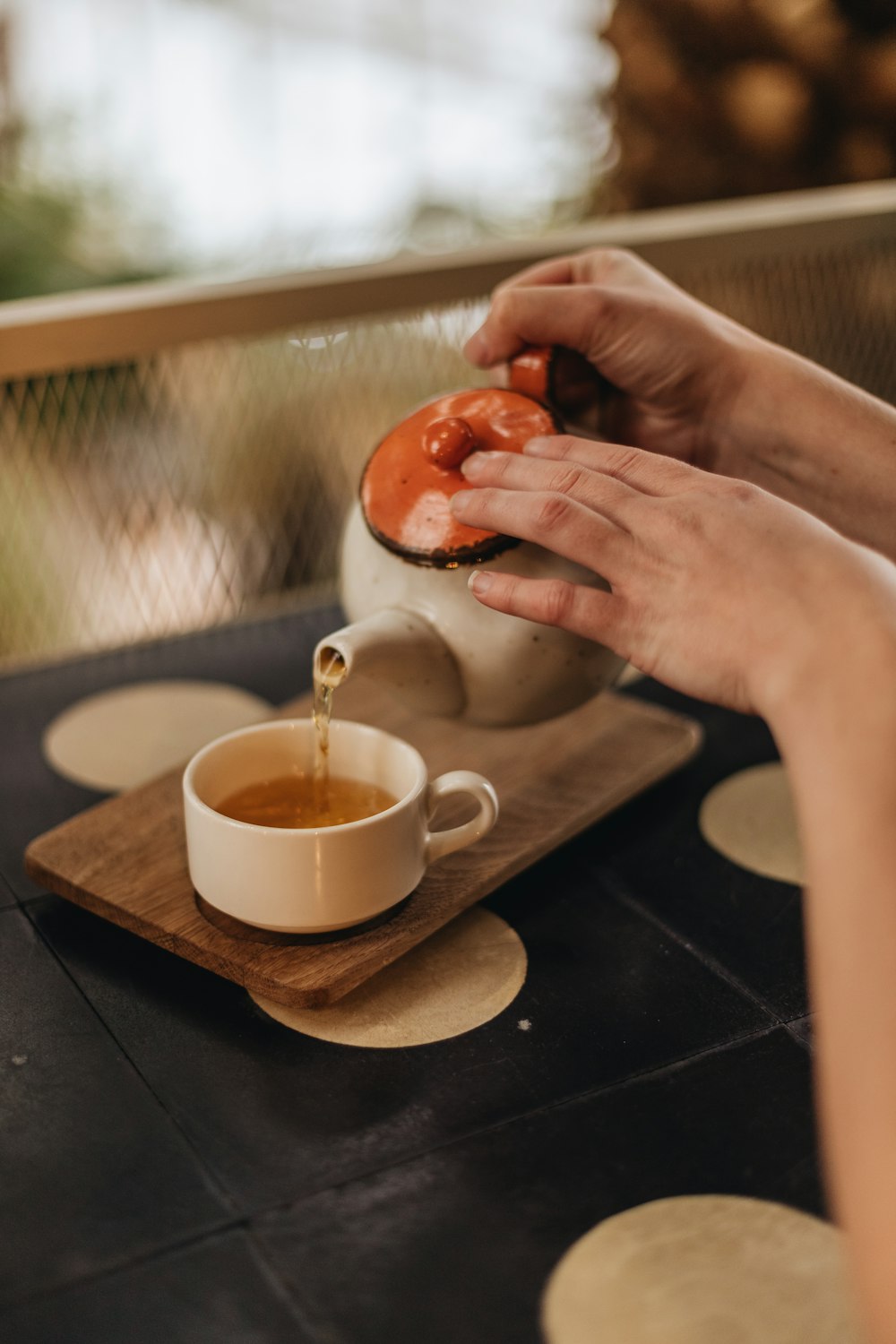 person pouring white liquid on white ceramic cup