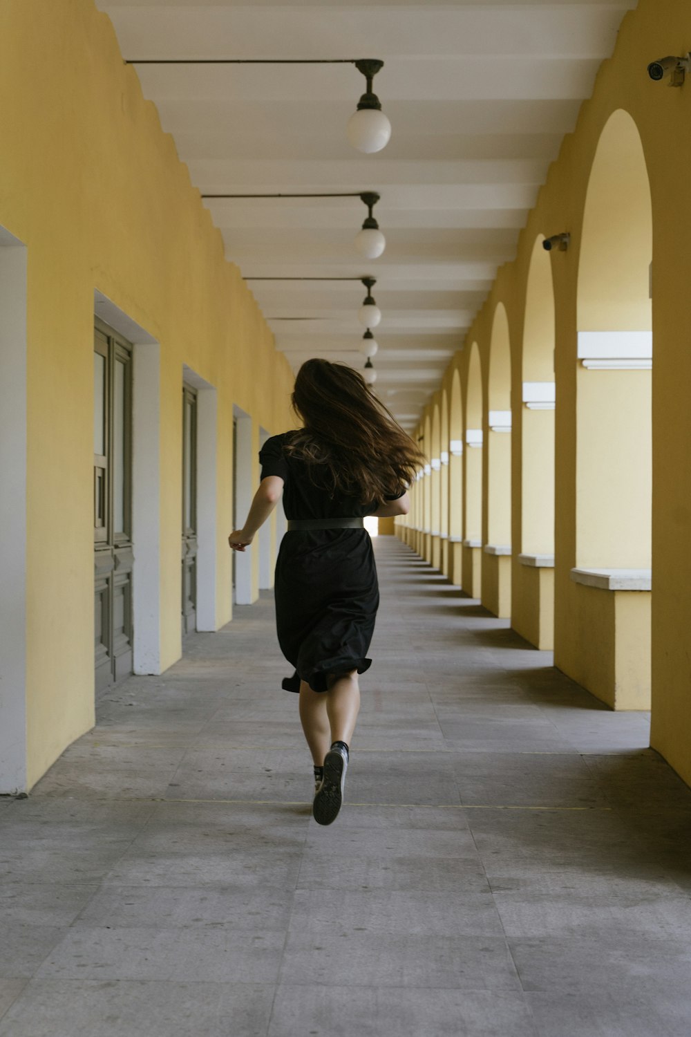 廊下を歩く黒いドレスの女性