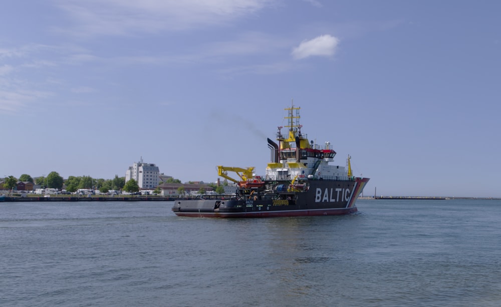 barco negro y rojo en el mar bajo el cielo azul durante el día