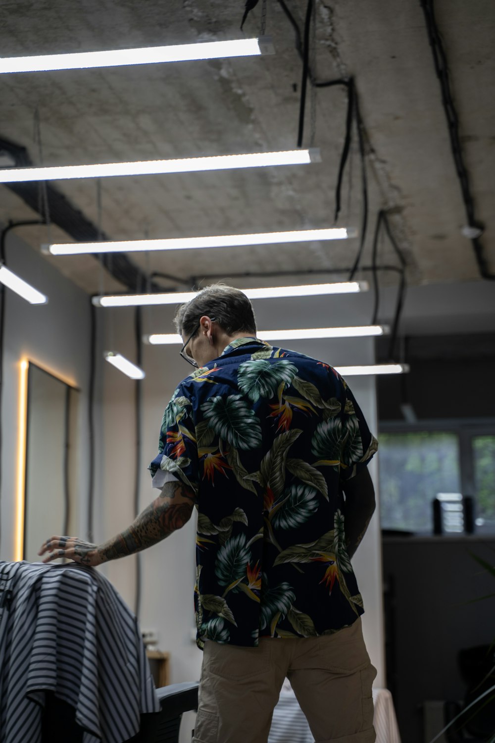 man in blue and yellow floral shirt standing