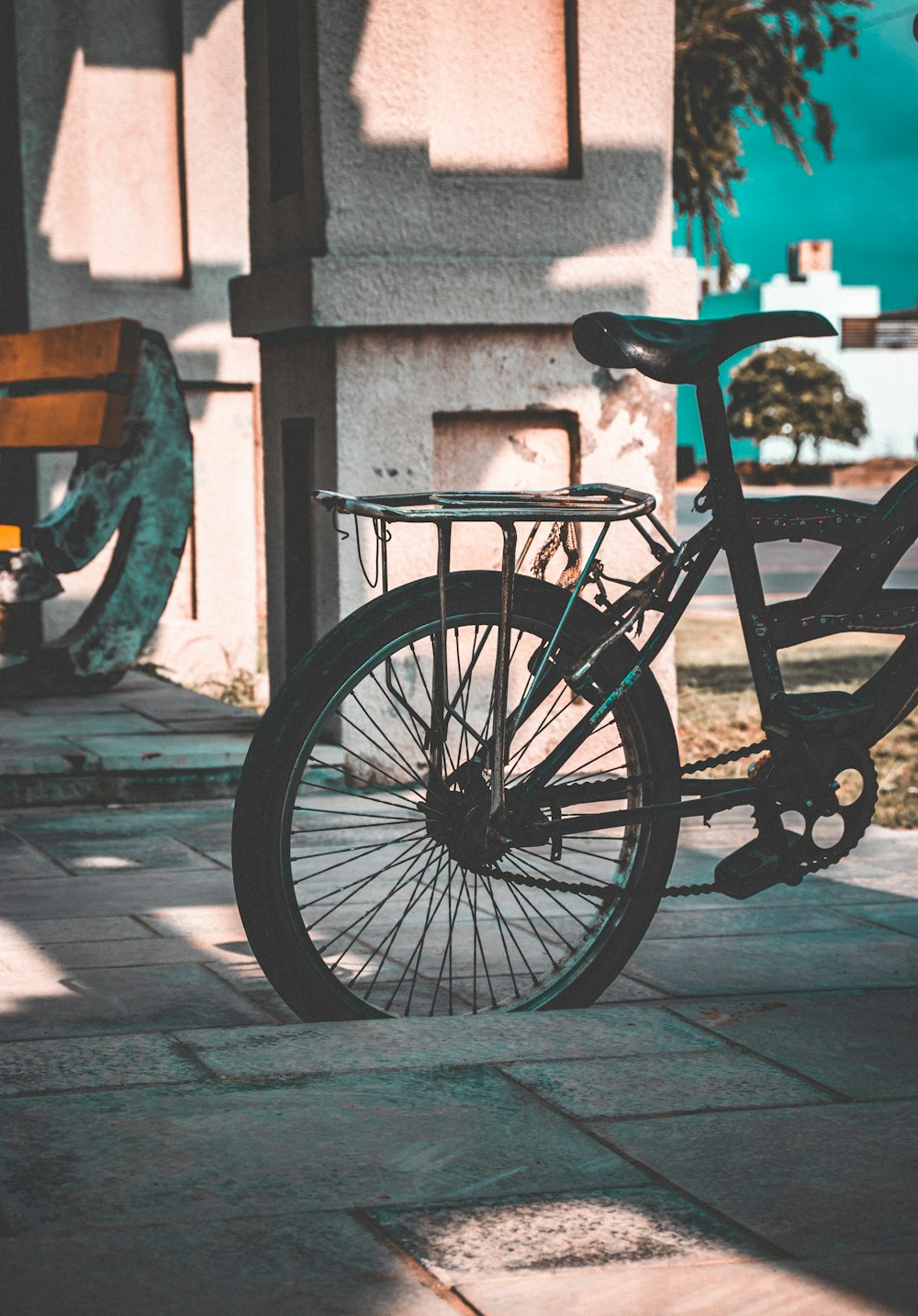 black bicycle parked beside gray concrete wall