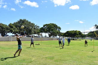 people playing soccer on green grass field during daytime