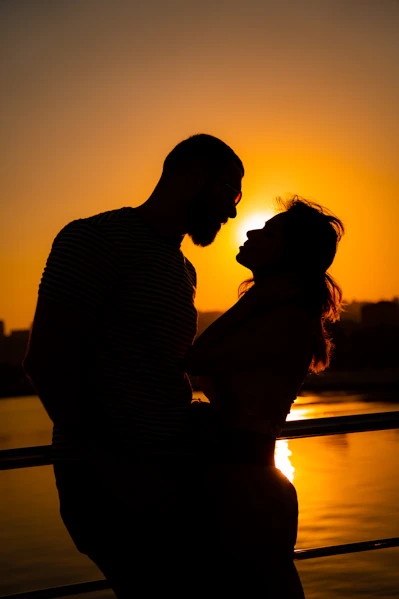 silhouette of man and woman kissing during sunset